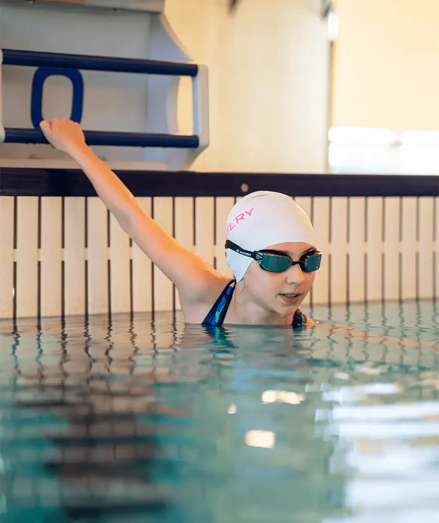Tyttö uimahallissa valmistautuu uimaan Watery Power Lane -uimalasien kanssa